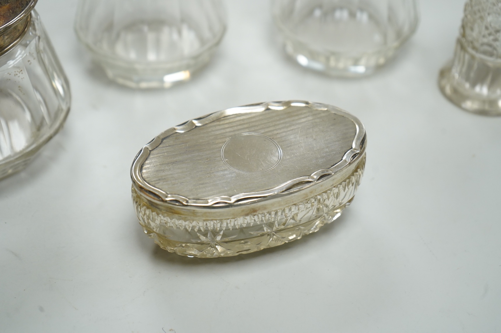 Three George V silver and tortoiseshell mounted glass toilet jars, Adie Brothers, Birmingham, 1925 & 1927, together with three other silver mounted glass toilet jars.